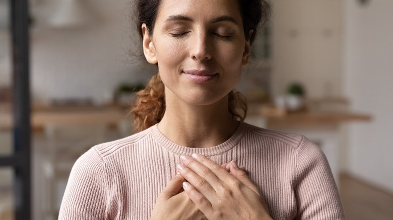 Woman with hands over heart