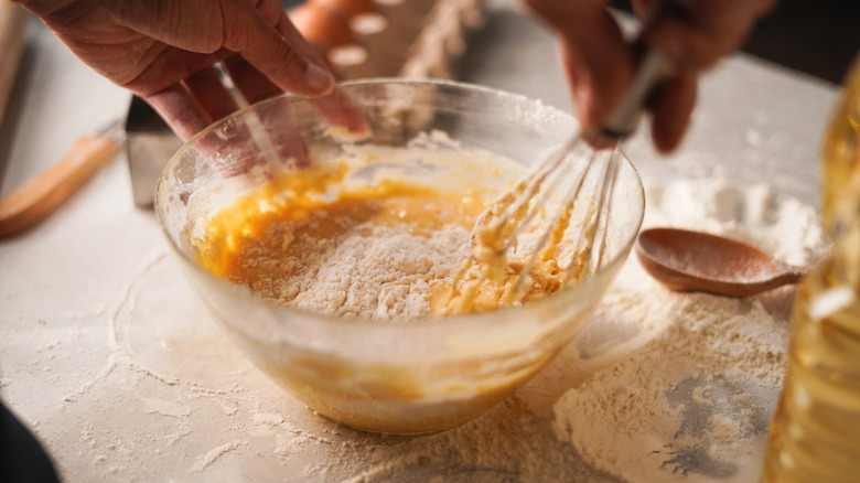 A metal whisk mixing together baking ingredients