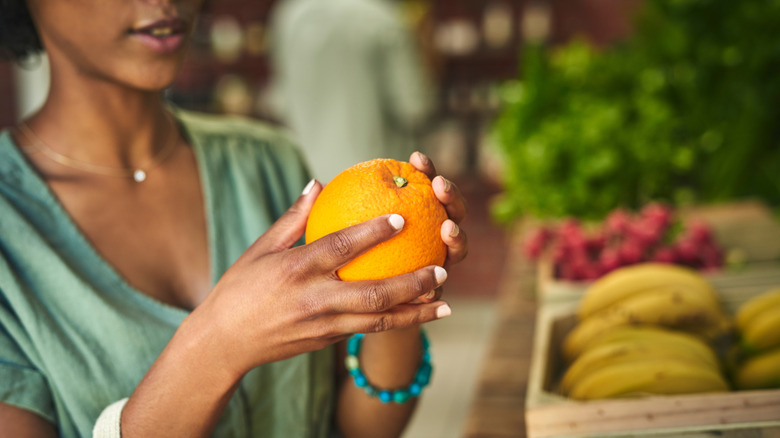 Woman selecting an orange