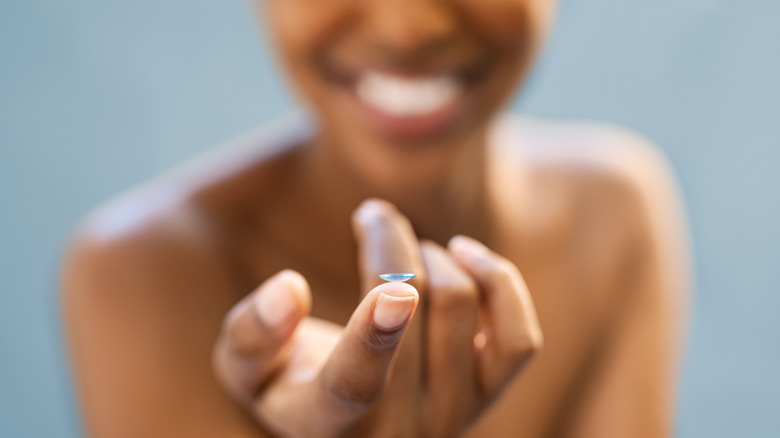 Close-up of woman's hand holding a contact lens