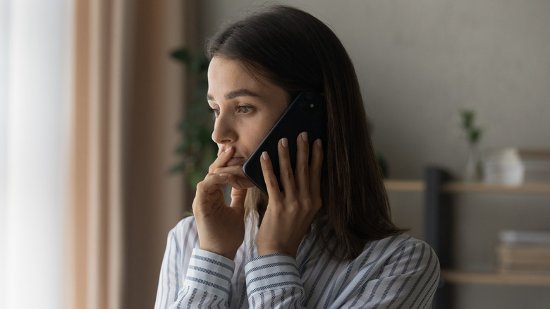 A woman looking uncertain while talking on the phone