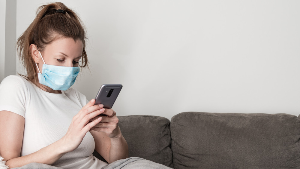 Woman wearing mask with phone