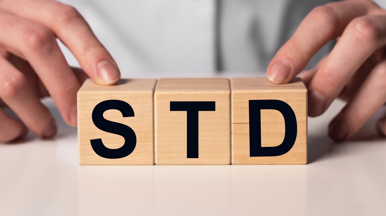 physician holding up blocks spelling out STD 