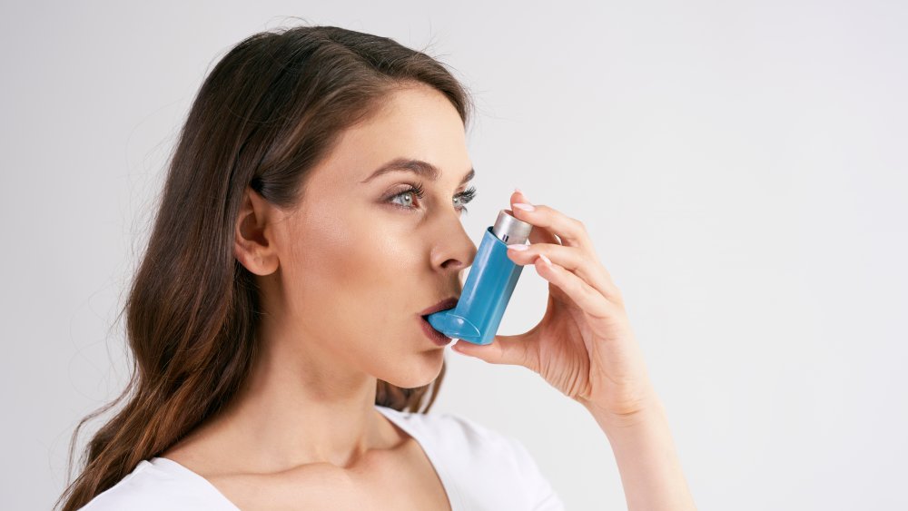 Woman using asthma inhaler