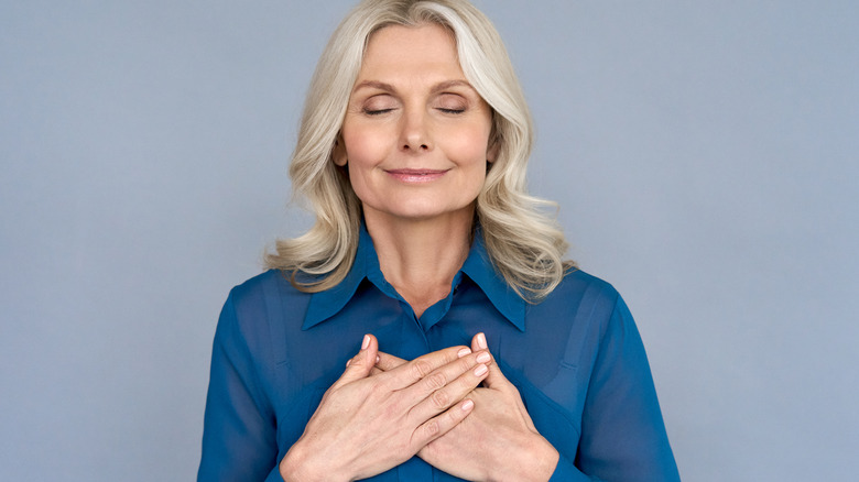 Woman holding hands over chest