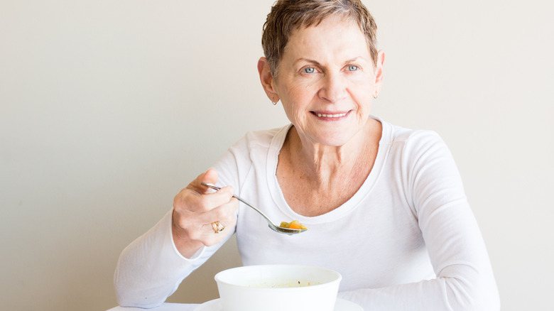 older woman eating soup