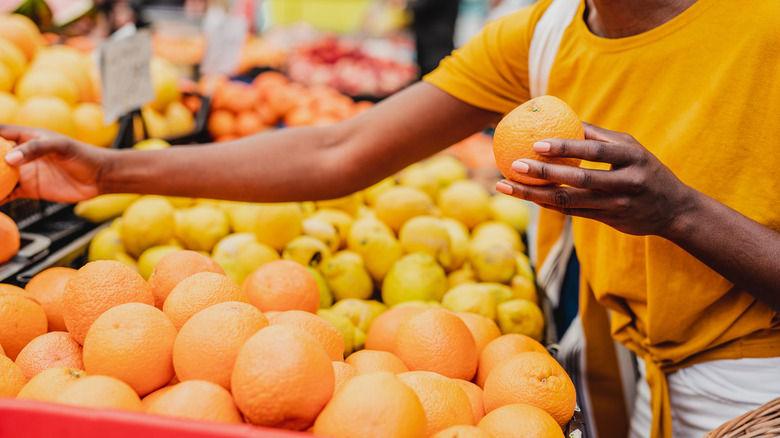 Woman shopping for citrus fruit