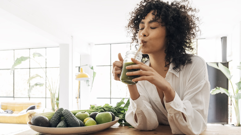 Woman sipping on green smoothie