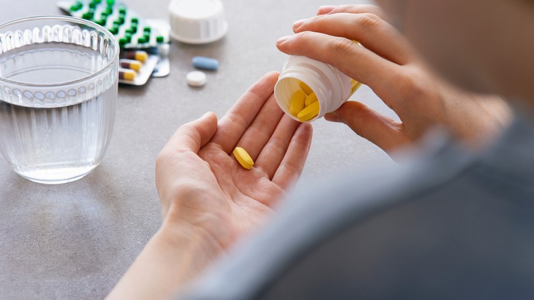 person holding pill with water