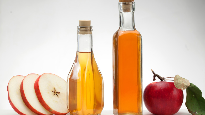 apple cider vinegar surrounded by apples