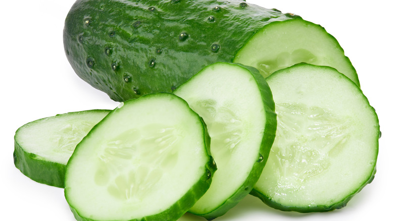 Cucumber half and slices on a white background