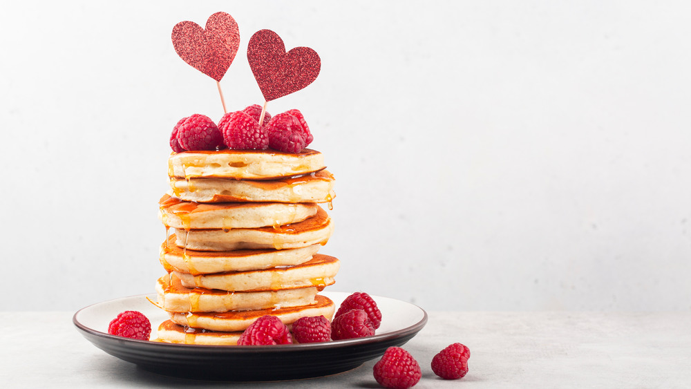 stack of pancakes topped with raspberries