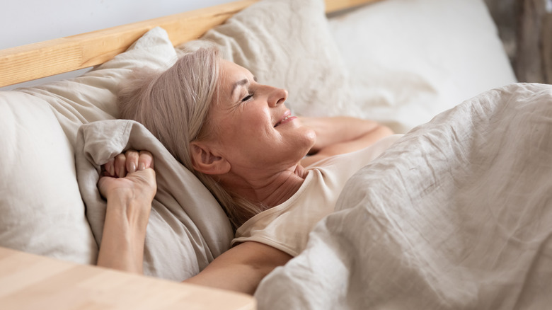 Woman happily waking from sound sleep