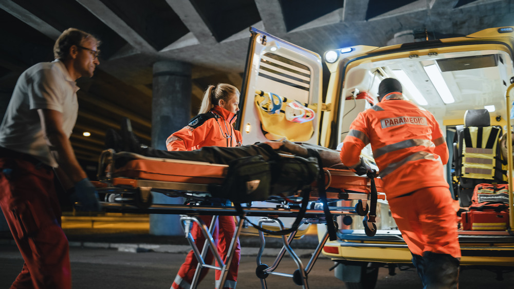 Paramedics load a patient into an ambulance