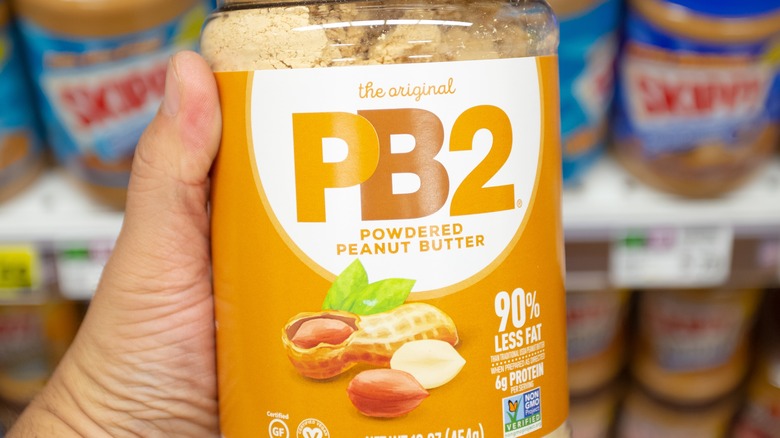 close up of hand holding jar of PB2 peanut butter