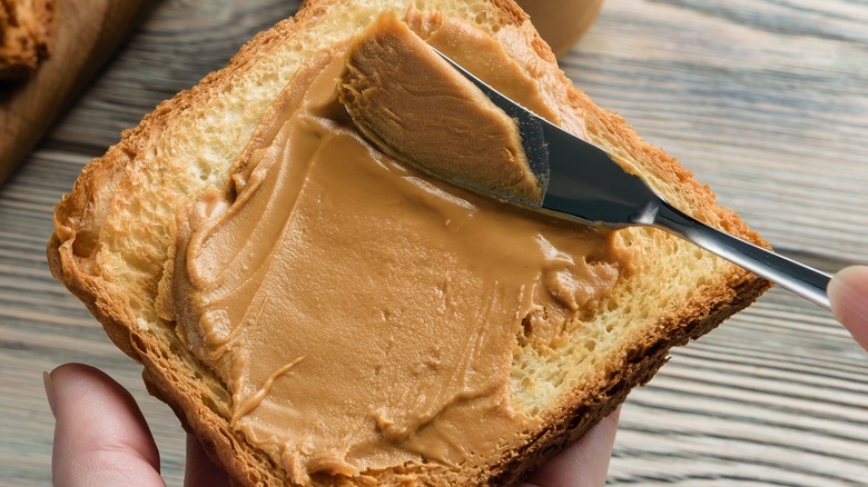 spreading peanut butter on toast