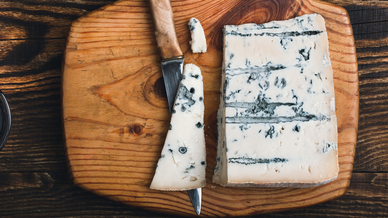 Top view of blue cheese on wooden cutting board