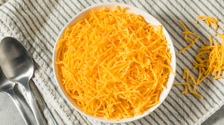 Shredded cheddar cheese in a bowl