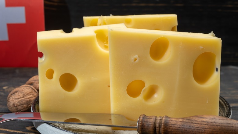 Blocks of Swiss cheese with knife and Swiss flag