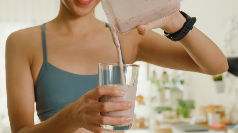 Sporty woman making a drink indoors