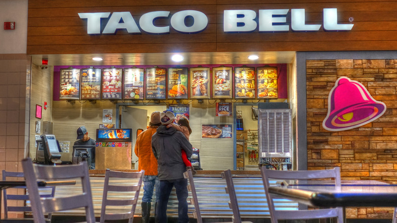 A family stands in front of a Taco Bell restaurant