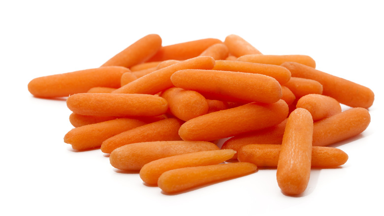 a pile of baby carrots in white background