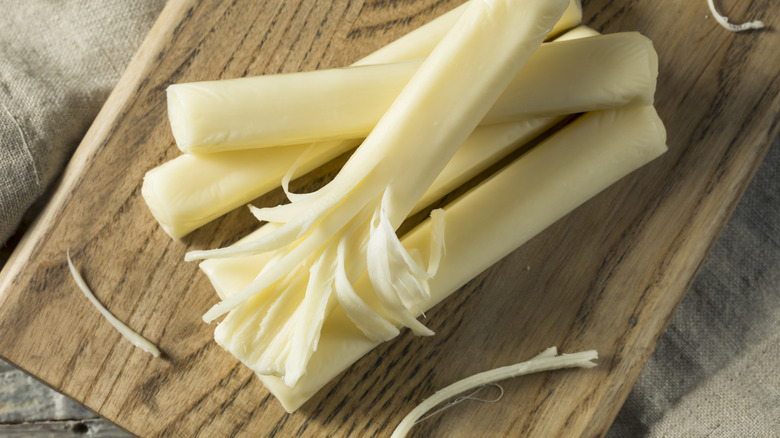 String cheese sticks with one peeled to reveal its stringiness