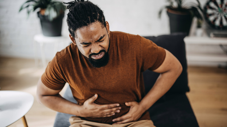 man holding his stomach in pain