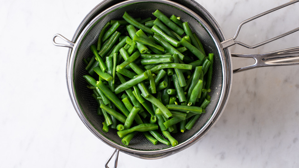 Blanched green beans in a mesh strainer