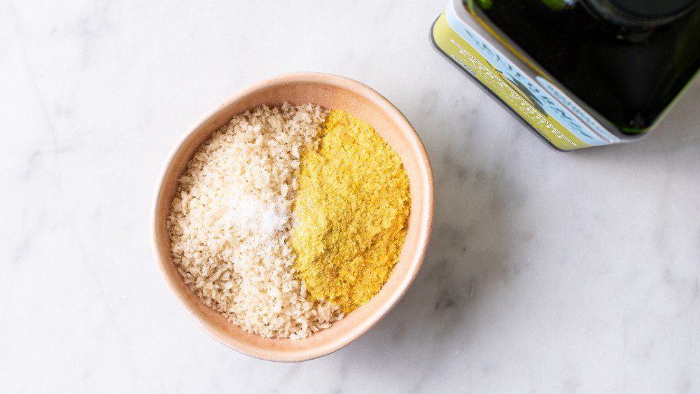 Panko and nutritional yeast in a small bowl next to olive oil