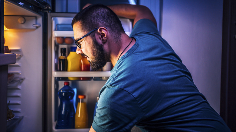 Man looking in refrigerator 