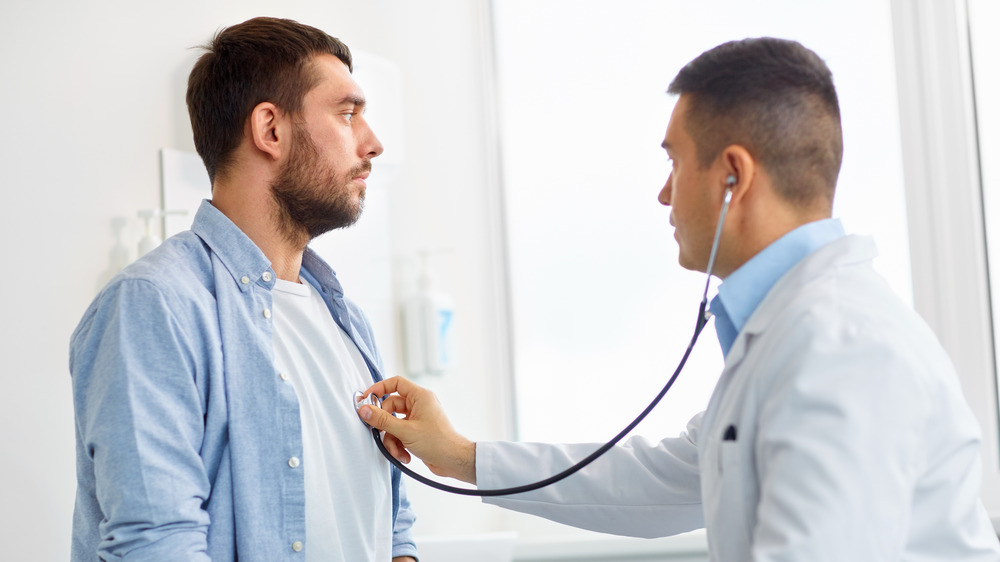 Man having his heart checked by a doctor with a stethoscope