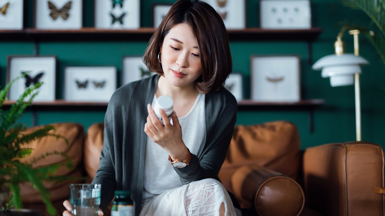 woman looking at her medicine bottle