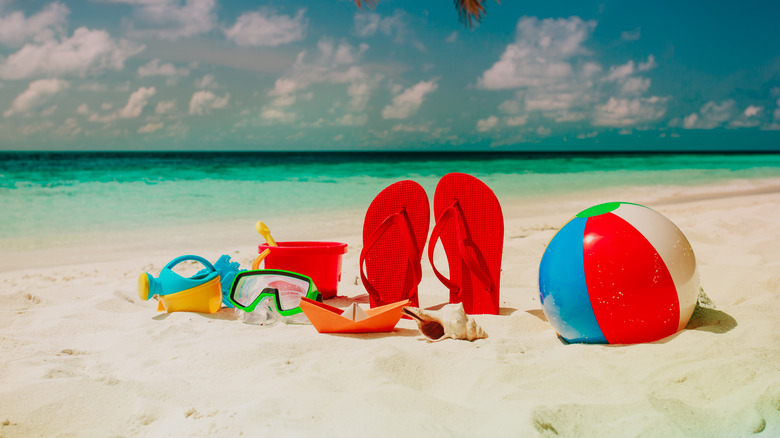 Flip flops and beach toys in the sand 