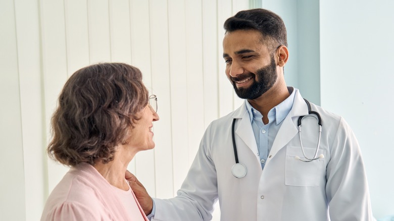 Doctor smiling reassuringly at his patient