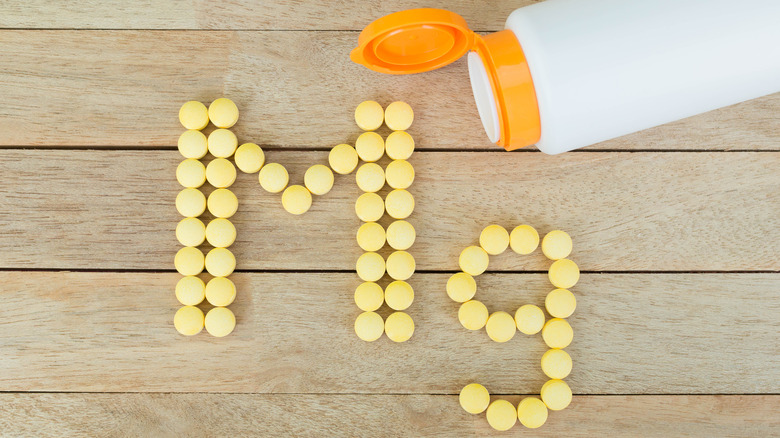 Pills spelling out "Mg" next to a bottle