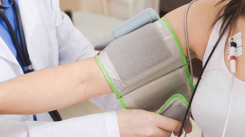 doctor testing patient's blood pressure 