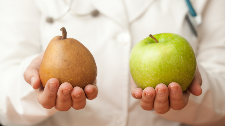 doctor's hands holding pear and apple