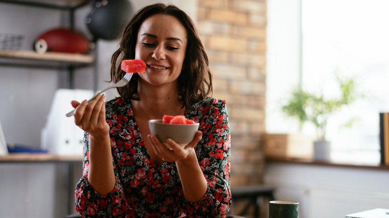 Woman eating bowl of watermelon