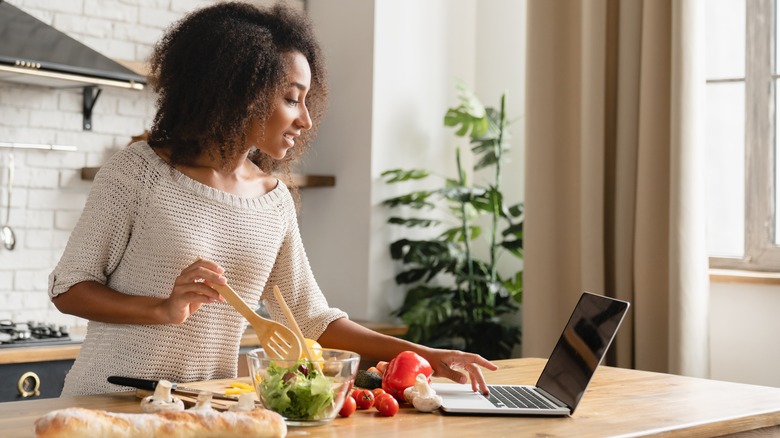 woman looking at recipe for salad online