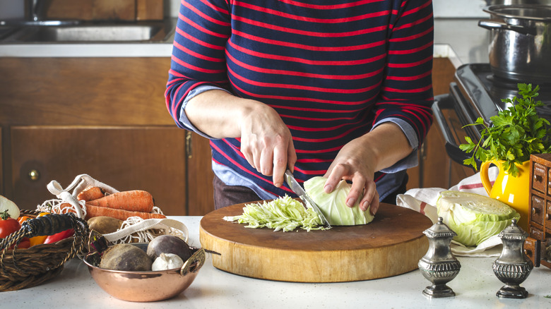 woman cutting cabbage in kitchen