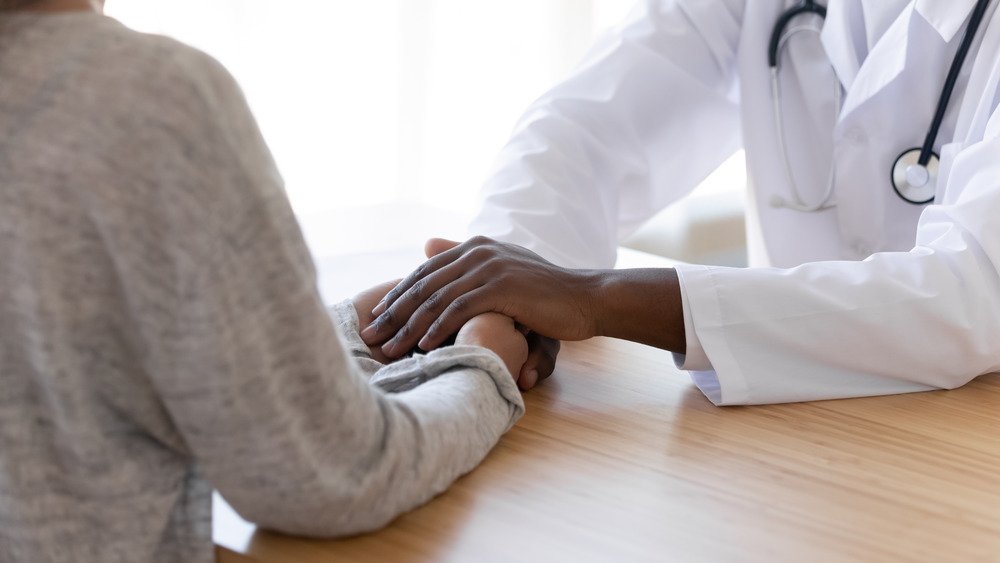 doctor holds a patient's hands