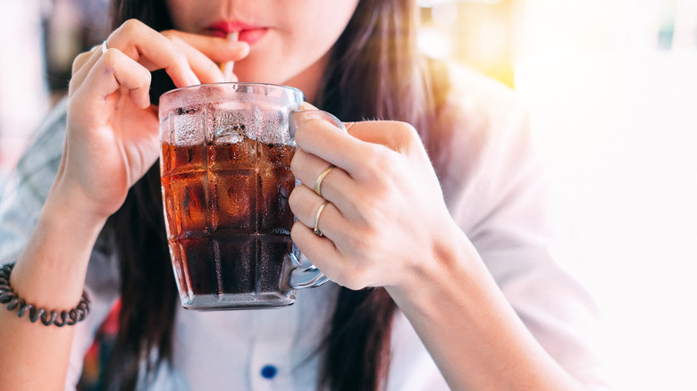 Woman drinking cola from glass