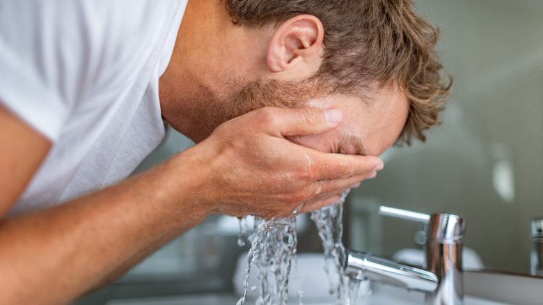 man washing his face