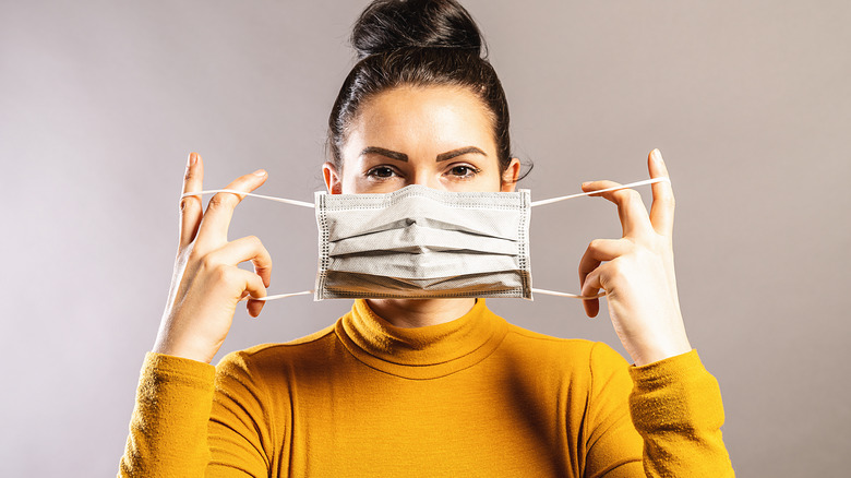 woman putting on mask