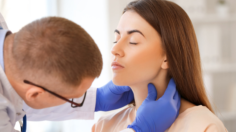 doctor examining woman's throat