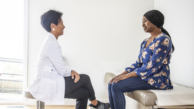 A woman talking to her doctor in an examination room