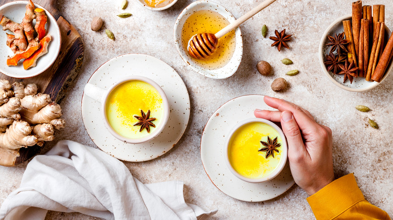 golden milk surrounded by honey and spices