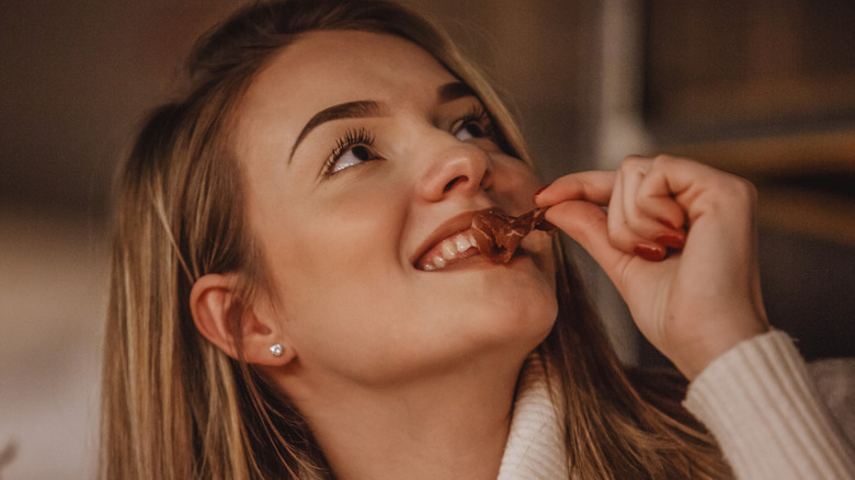 woman eating dried snack and smiling