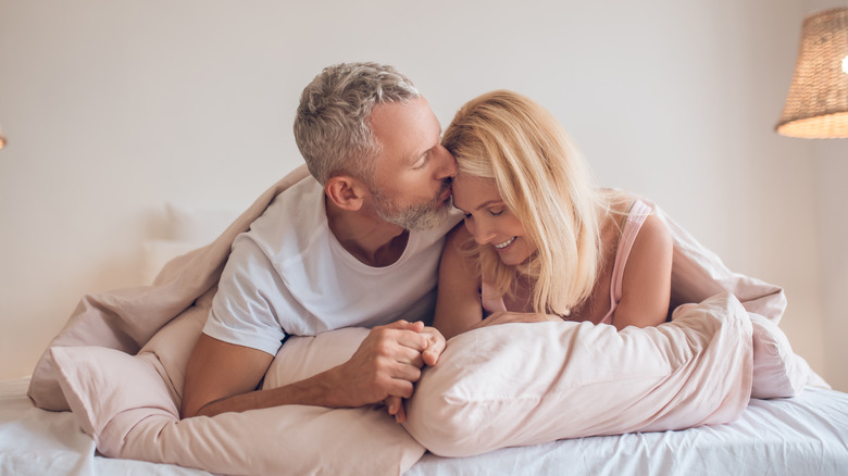 gray haired man and woman in bed